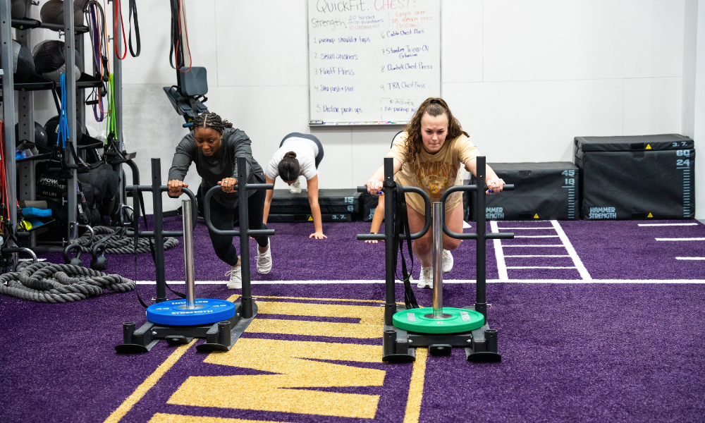 students pushing a sled as part of their workout class